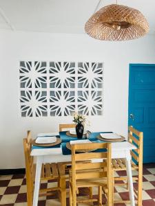een eetkamer met een tafel met stoelen en een muur bij La Casita De Emma in Ríohacha