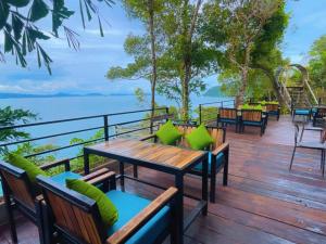 高龙撒冷岛The Cliff Hostel, M'Pay Bay的摆放着桌椅、可以俯瞰水面的甲板