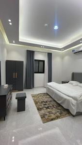 a bedroom with a bed and a dresser and a table at قمة حياة للشقق المفروشة in Hafr Al Baten
