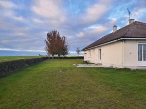 a white building with a picnic table next to a field at A l'horizon du Mont in Pontorson
