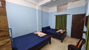 a room with two beds and a window at Mountain Rooms And Homestay in Vagamon