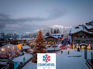 une ville avec un sapin de Noël dans la neige dans l'établissement Cosy et Spacieux 105m² à Courchevel 1850 - 6 Pers - Centre Station, Proche Pistes, Confort & Équipements - FR-1-631-162, à Courchevel