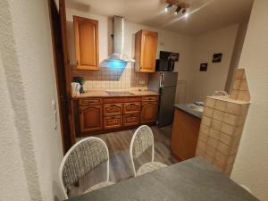 a kitchen with wooden cabinets and a table and chairs at Elbe Quartier Meissen TOP MONTEURUNTERKÜNFTE Wohnung 12 in Meißen
