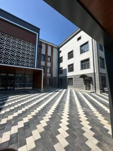 een lege binnenplaats van een gebouw met twee gebouwen bij Tahtapul Expo Hotel in Tasjkent