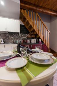 ein Tisch mit Tellern und Gläsern darauf in der Unterkunft Ortigia Deluxe S.A.L. in Syrakus