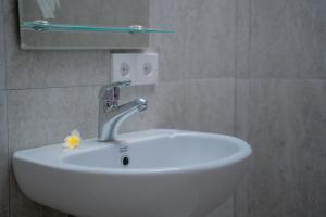 a white sink in a bathroom with a flower on it at Padma Graha Villa in Candidasa