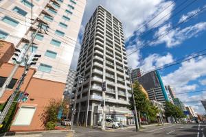 een hoog gebouw op de hoek van een stadsstraat bij Cozy Stay Sapporo Central Nakajima in Toyohira
