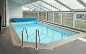 ein Swimmingpool in einem Glashaus in der Unterkunft Amazing Home In Ebeltoft With Sauna in Ebeltoft