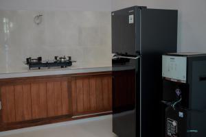 a black refrigerator in a room with a counter at Padma Graha Villa in Candidasa