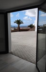 a sliding glass door with a palm tree in the background at Casa Calma in Las Breñas