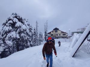 a man walking down a snow covered road at Smart Hotels in Dalhousie