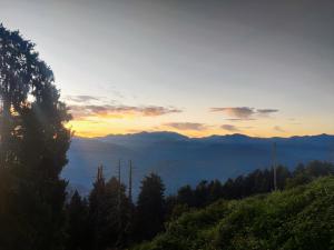 a view of the mountains with the sun setting at Smart Hotels in Dalhousie