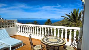 a balcony with a table and chairs and the ocean at Vv Casa Lucas A 15 Minutos del Garajonay in Vallehermoso