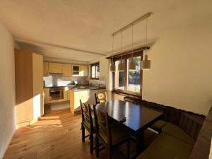 Una cocina y un comedor con mesa y sillas. en Casa Siccardi, en Klosters Serneus 3 fotos más