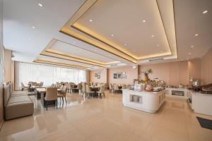 een grote eetkamer met tafels en stoelen bij Wanxin Zhige Hotel in Zhangla