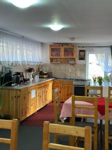 a kitchen with wooden cabinets and a table and chairs at Pensiunea Maria in Lacu Rosu