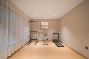 een kamer met een fitnessruimte met een loopband en gordijnen bij Wanxin Zhige Hotel in Zhangla