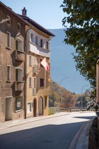 a building with a flag on the side of a street at Garni Pola in Brusio