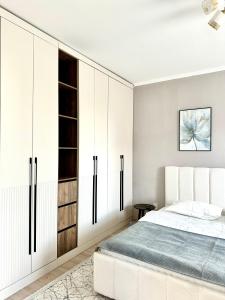 a bedroom with white cabinets and a bed at 1 комнатные апартаменты in Atyraū