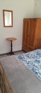 a bedroom with a bed and a table and a mirror at 5 Cliff Street in Agulhas