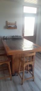 a large wooden table with two chairs around it at 5 Cliff Street in Agulhas +7 photos