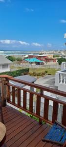 a wooden deck with a blue bench on a balcony at 5 Cliff Street in Agulhas