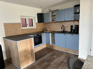 Una cocina con gabinetes azules y una encimera. en Ferienwohnung Innblick, en Marktl