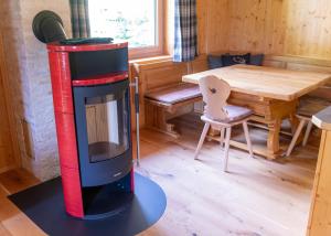 a wood stove in a room with a table at JAUCHZA! Chalet in Innerkrems +10 photos