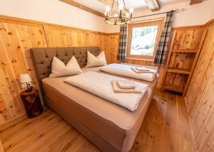 a bedroom with two beds in a wooden room at JAUCHZA! Chalet in Innerkrems