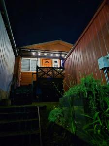 a house with lights on the side of it at night at Cabañas Tupananchiskama in Ancud +2 photos