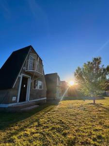 a barn with the sun setting in the background at ALTO VERDE Lodge in Potrero de los Funes