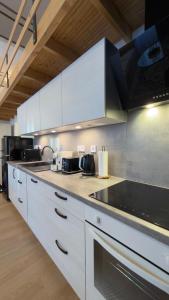 a kitchen with white cabinets and a counter top at Apartmán U Hradu in Strakonice