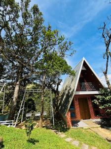 a red brick house with a metal roof at Ninans Hide Out in Santhanpara