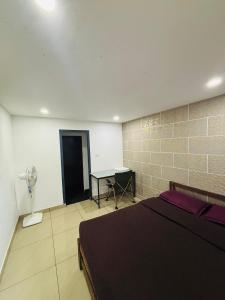 Schlafzimmer mit einem Bett und einem Schreibtisch mit einem Ventilator in der Unterkunft Ninans Hide Out in Santhanpara