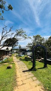 ein Feldweg mit einem Bogen im Gras in der Unterkunft Ninans Hide Out in Santhanpara