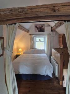 a bedroom with a large bed and a window at The Old Barn in Bettws Gwerfil Goch +12 photos