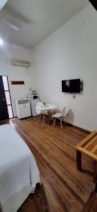 a bedroom with a bed and a table and a kitchen at Monoambiente en Puerto Nuevo in Concepción del Uruguay