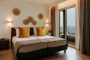 a hotel room with a bed and a balcony at Hotel Euro Moniz in Porto Moniz