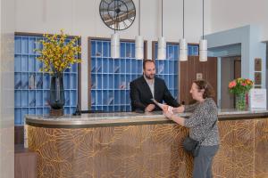 a man and a woman standing behind a counter at Domitys L'Ellipse in Paris +36 photos
