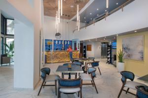 a lobby with tables and chairs and a woman standing in the background at Domitys L'Ellipse in Paris