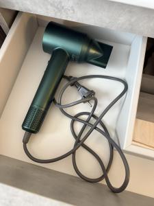 ein grüner Haartrockner, der aus einer Kiste ragt in der Unterkunft La mansarda in montagna - Roccaraso in Roccaraso