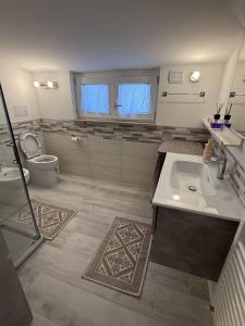 ein Badezimmer mit Waschbecken und Toilette in der Unterkunft La mansarda in montagna - Roccaraso in Roccaraso + 11 Fotos