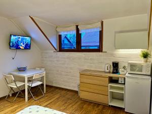 a small kitchen with a table and a counter top at Willa Avita in Karpacz