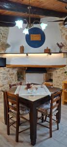 a dining room table with two chairs and a chandelier at Emvassis Art Nil in Elefterna