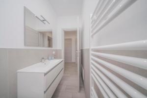 ein weißes Badezimmer mit Waschbecken und Spiegel in der Unterkunft Scopri Torino da una posizione privilegiata! in Turin