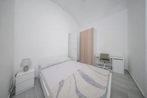 ein weißes Schlafzimmer mit einem Bett und einem Schreibtisch in der Unterkunft Scopri Torino da una posizione privilegiata! in Turin
