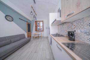 eine Küche und ein Wohnzimmer mit einer Couch und einem Tisch in der Unterkunft Scopri Torino da una posizione privilegiata! in Turin