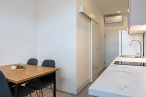 a kitchen and dining room with a wooden table and chairs at Urban NEST apartment - FREE Parking & Central in Kočevje