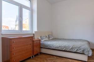 a bedroom with a bed and a dresser and a window at Urban NEST apartment - FREE Parking & Central in Kočevje