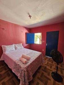 a bedroom with a bed with red walls and a chair at Pousada Brilho do Mar in Guriú +15 photos